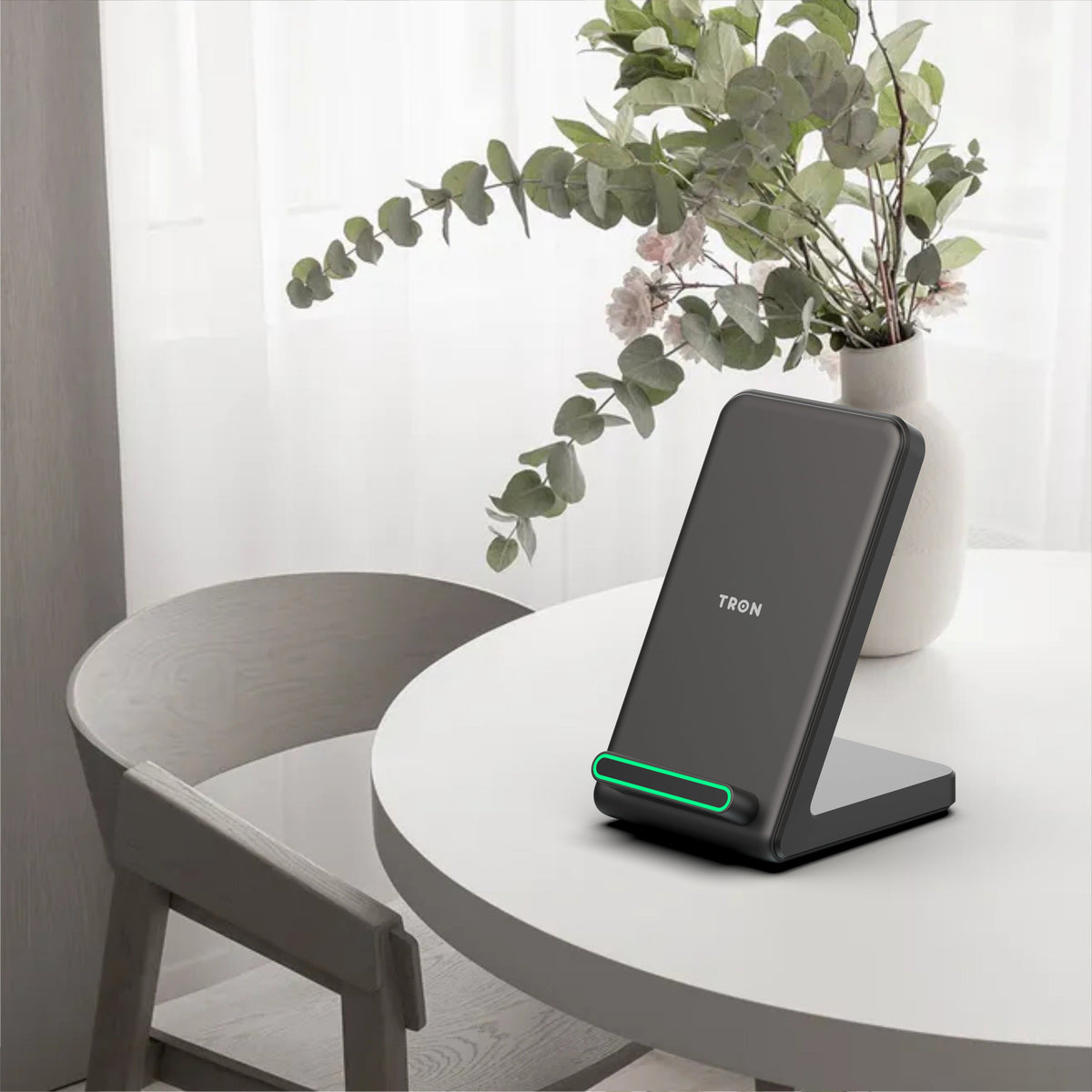 Tron wireless charging stand on a table with a phone charging